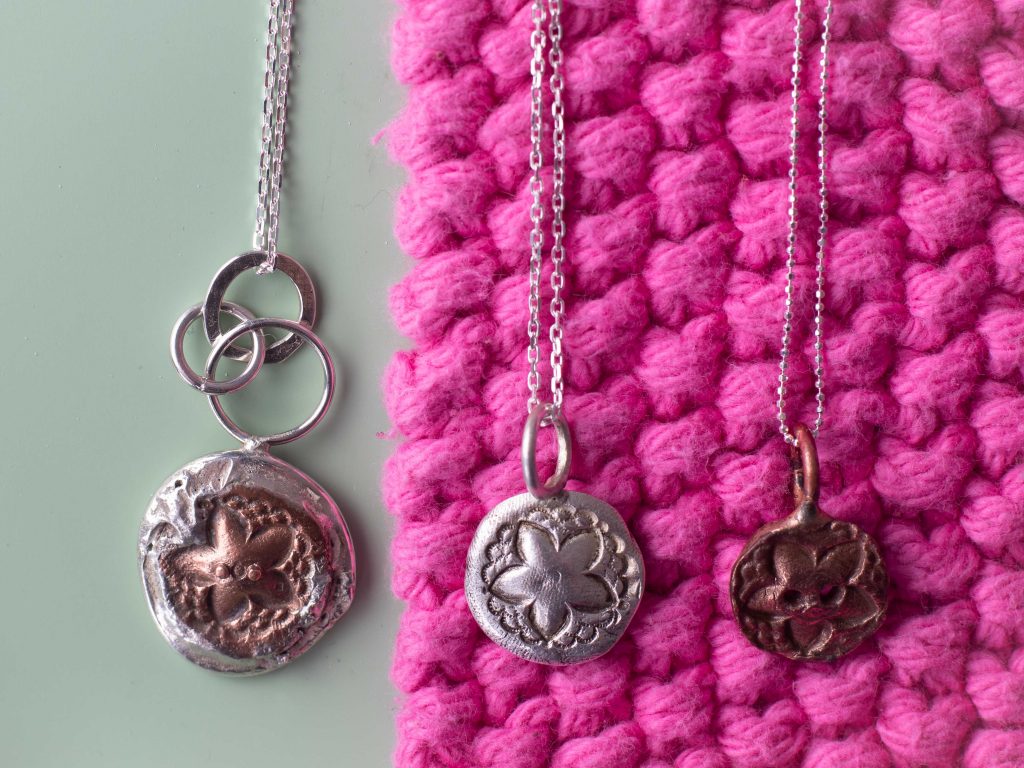 Reversible button pendant with two other button pendants.