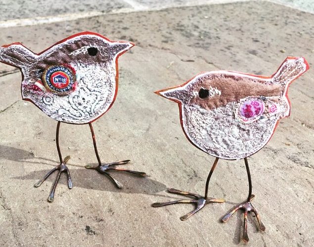 Two embroidered wrens with copper bodies